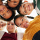 Worm's Eye View Of A Huddle Of Children Looking At The Camera