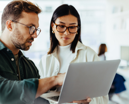 Design Professionals Using A Laptop Together In An Office